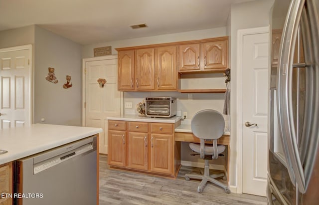 kitchen featuring appliances with stainless steel finishes and light hardwood / wood-style floors