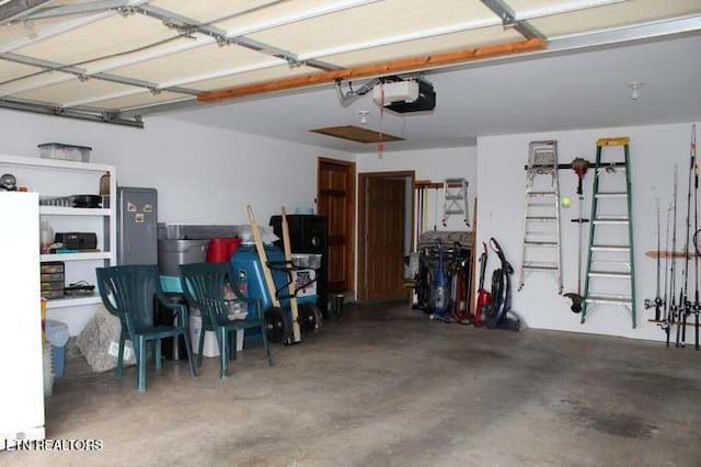 garage with white refrigerator and a garage door opener