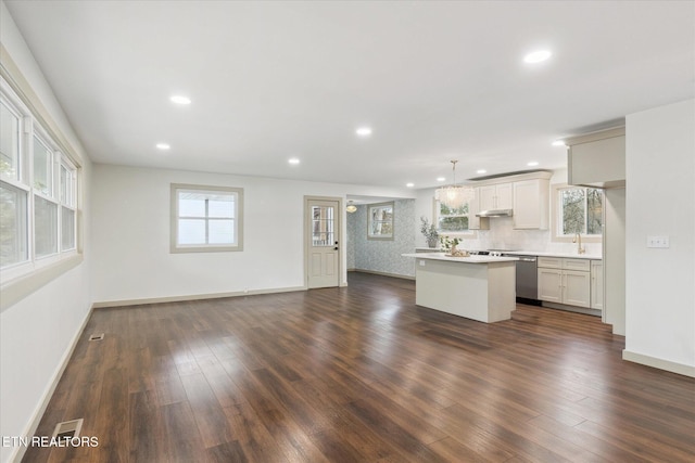 kitchen featuring sink, dark wood-type flooring, dishwasher, hanging light fixtures, and a center island