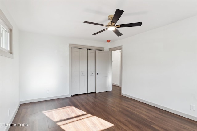 unfurnished bedroom featuring a closet, dark hardwood / wood-style floors, and ceiling fan