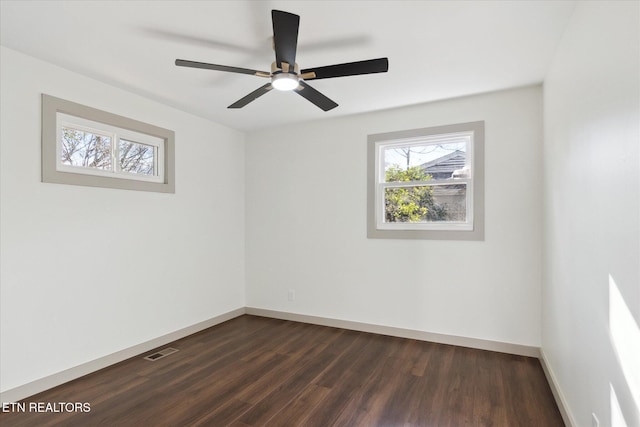 spare room with ceiling fan, a healthy amount of sunlight, and dark hardwood / wood-style flooring