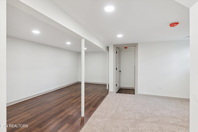 basement with dark hardwood / wood-style floors