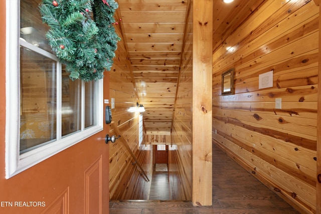 hallway featuring wood-type flooring, lofted ceiling, wooden ceiling, and wooden walls