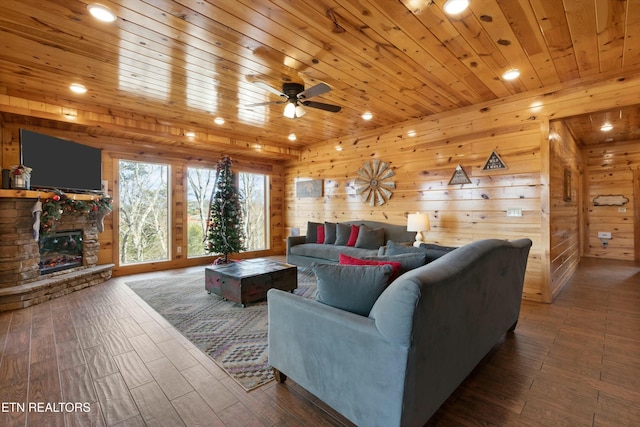 living room with ceiling fan, a fireplace, wood ceiling, and wood walls