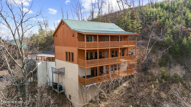 back of house featuring a balcony and central AC