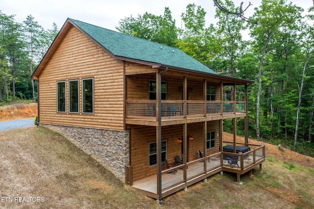 rear view of house with a wooden deck and a balcony