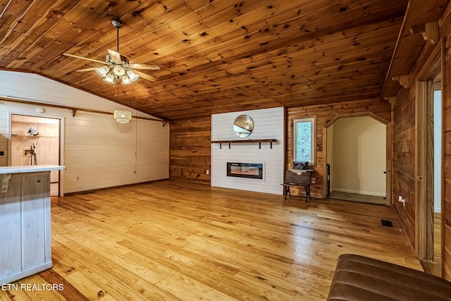 unfurnished living room with lofted ceiling, light hardwood / wood-style flooring, wooden ceiling, wooden walls, and a fireplace