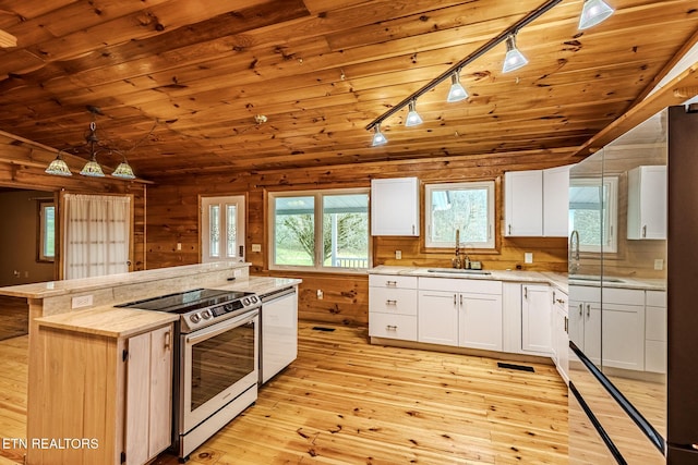 kitchen with sink, white cabinetry, decorative light fixtures, stainless steel electric stove, and light hardwood / wood-style floors