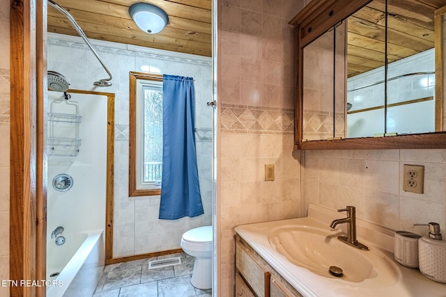 full bathroom with shower / bath combination, vanity, tile walls, and toilet