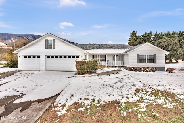 view of front of property featuring a porch, a garage, and a mountain view