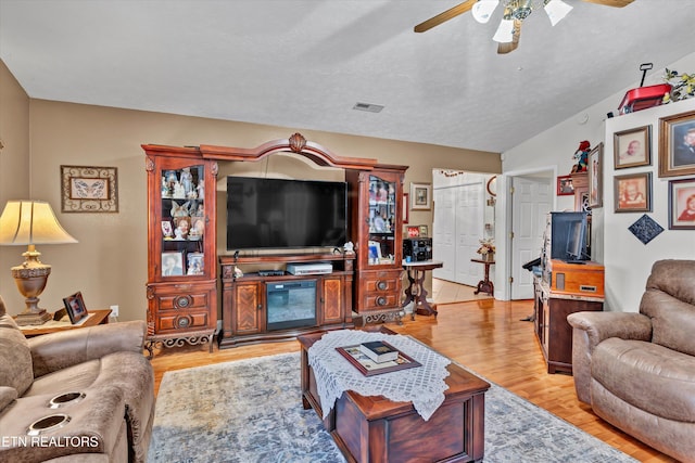 living room featuring lofted ceiling, light hardwood / wood-style flooring, and ceiling fan