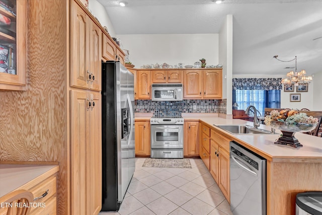 kitchen with pendant lighting, sink, light tile patterned floors, appliances with stainless steel finishes, and backsplash