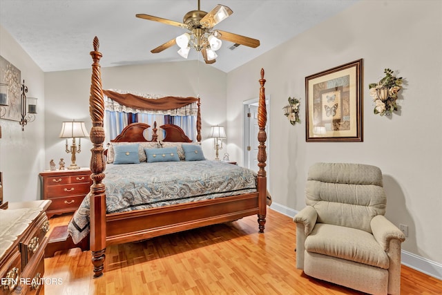 bedroom with hardwood / wood-style floors, vaulted ceiling, and ceiling fan