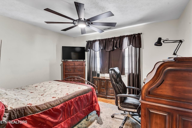 bedroom featuring ceiling fan and a textured ceiling