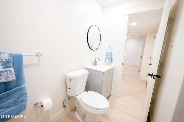 bathroom featuring vanity, toilet, and hardwood / wood-style floors