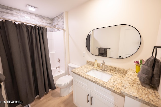 full bathroom with hardwood / wood-style flooring, shower / tub combo with curtain, vanity, and toilet