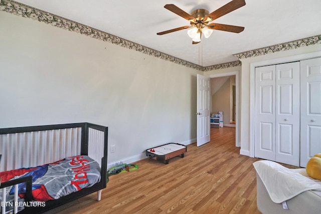 bedroom featuring wood-type flooring, ceiling fan, and a closet