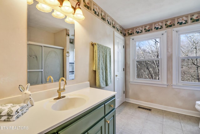 bathroom featuring a chandelier, vanity, walk in shower, toilet, and tile patterned floors