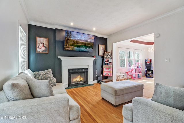 living room featuring crown molding, hardwood / wood-style flooring, and a chandelier