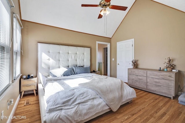 bedroom with hardwood / wood-style floors, high vaulted ceiling, and ceiling fan