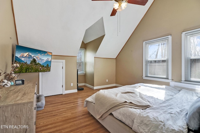 bedroom with ceiling fan, lofted ceiling, and light wood-type flooring