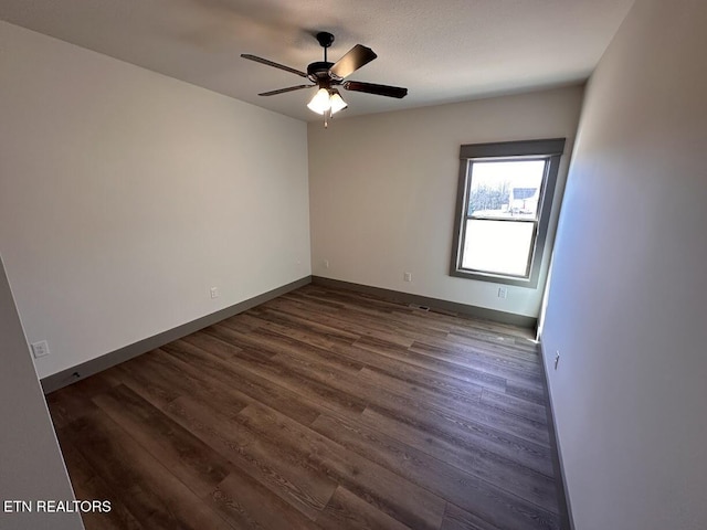 spare room featuring ceiling fan and dark hardwood / wood-style flooring