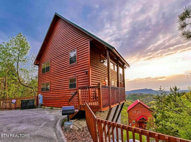 property exterior at dusk with a deck with mountain view