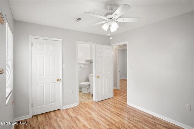 unfurnished bedroom featuring connected bathroom and light wood-type flooring