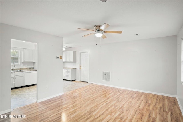 unfurnished living room with ceiling fan, sink, and light wood-type flooring