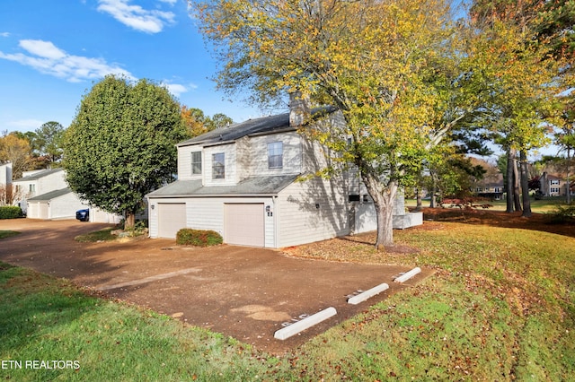 view of home's exterior featuring a garage and a lawn