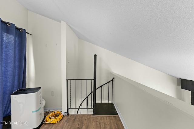 hallway featuring wood-type flooring and a textured ceiling