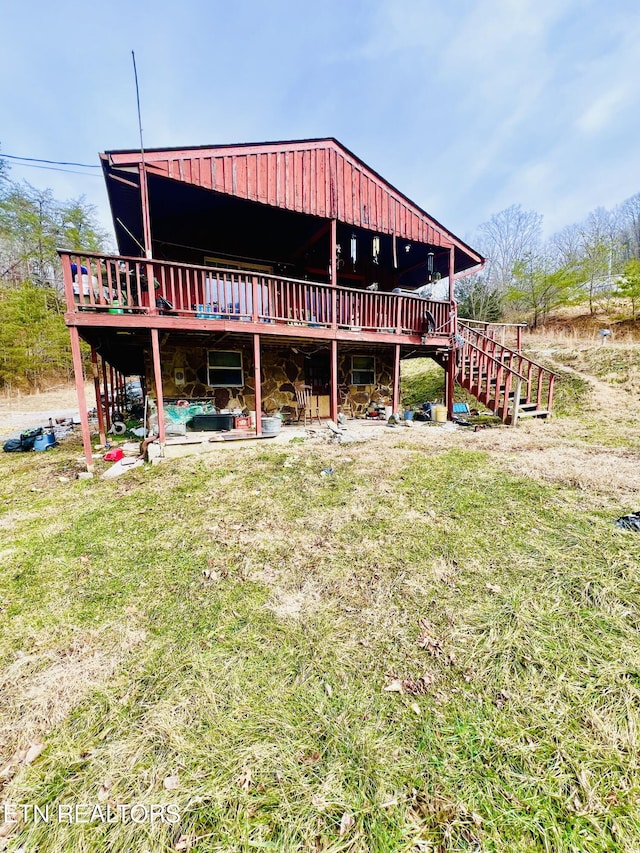 rear view of property with a wooden deck and a yard