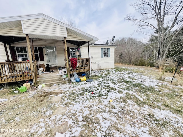 view of snow covered rear of property