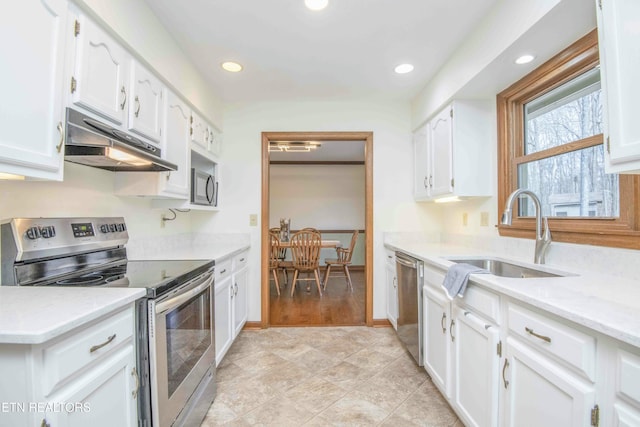 kitchen featuring stainless steel appliances, white cabinetry, and sink