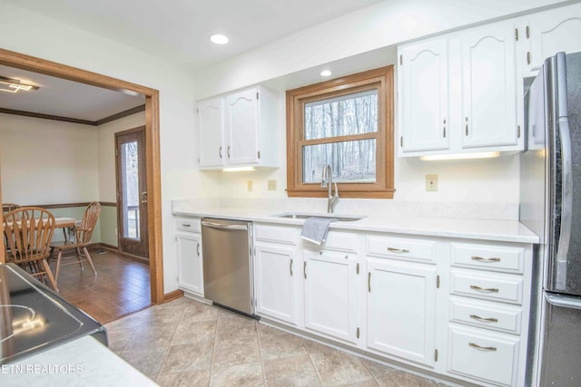 kitchen featuring sink, crown molding, light hardwood / wood-style flooring, appliances with stainless steel finishes, and white cabinets