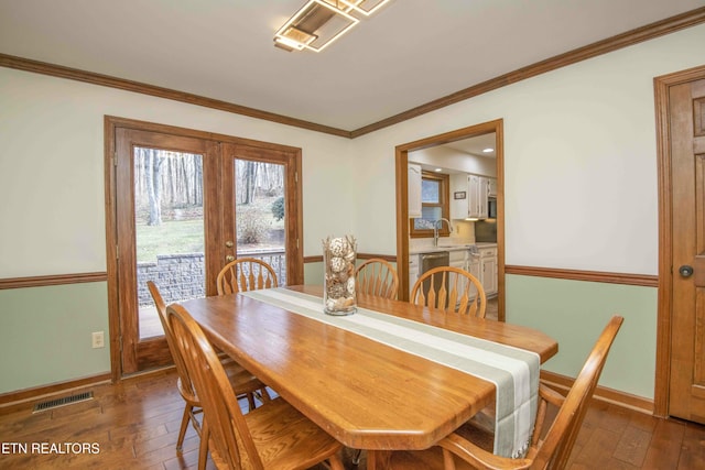 dining room with crown molding, sink, and dark hardwood / wood-style flooring