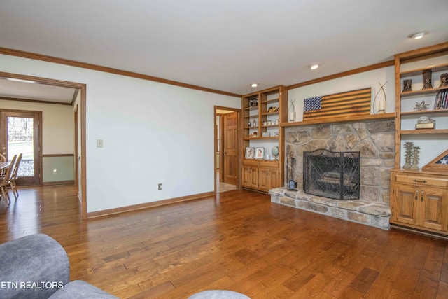 living room featuring ornamental molding, a stone fireplace, and hardwood / wood-style floors