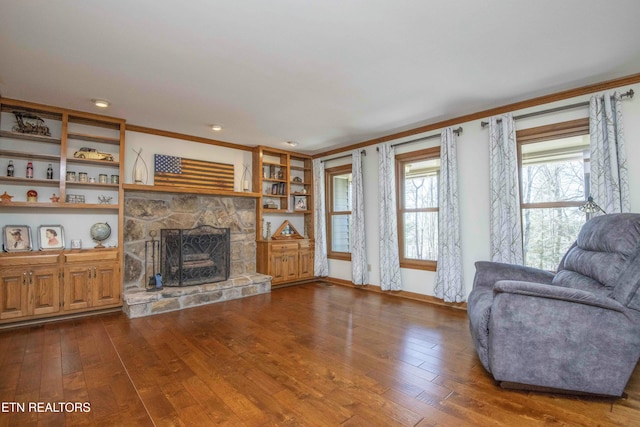 living room featuring ornamental molding, dark wood-type flooring, and a fireplace