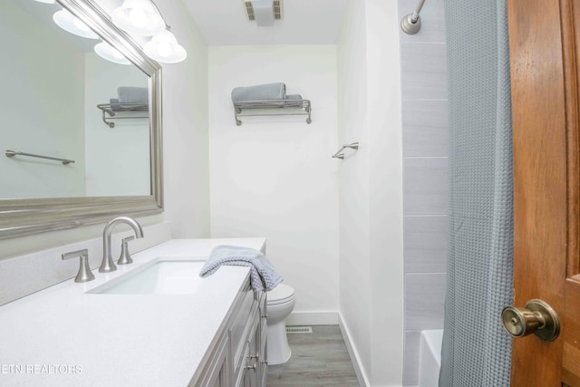 full bathroom featuring shower / tub combo, vanity, toilet, and hardwood / wood-style floors