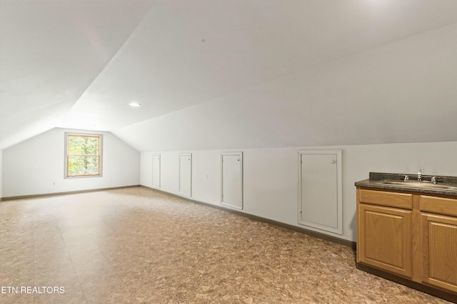 additional living space featuring sink and vaulted ceiling