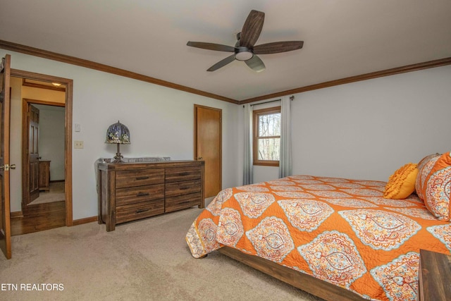 carpeted bedroom featuring crown molding and ceiling fan