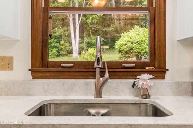 room details with light stone countertops and sink