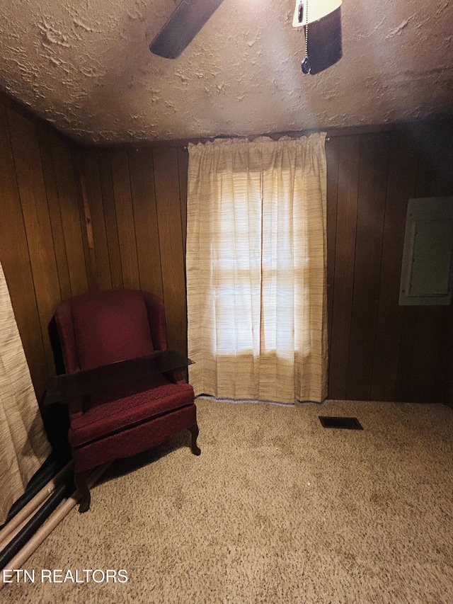 living area with carpet flooring and wood walls