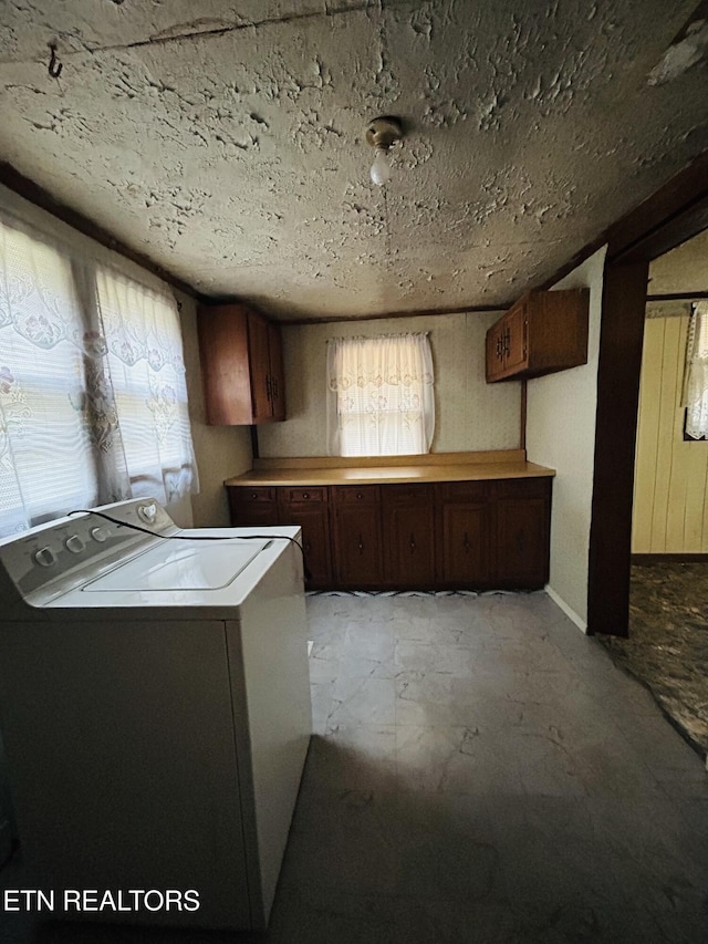 kitchen with dark brown cabinetry, plenty of natural light, and washer / clothes dryer