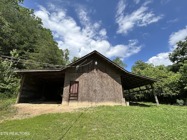 view of property exterior with an outdoor structure and a yard