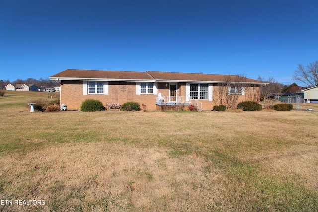 ranch-style home featuring a front yard and brick siding