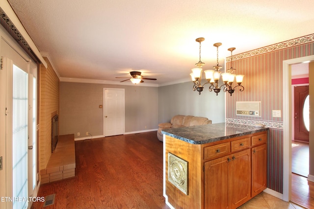 kitchen featuring brown cabinets, light wood-style flooring, ornamental molding, a brick fireplace, and wallpapered walls