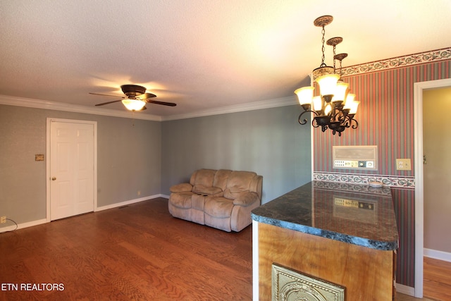 living area featuring a textured ceiling, baseboards, dark wood-type flooring, and ornamental molding