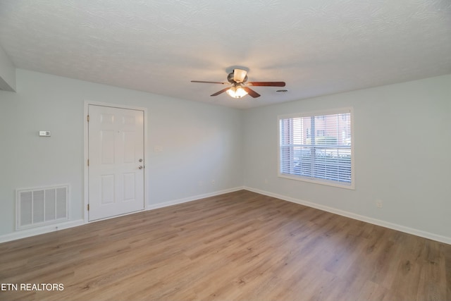 spare room featuring a textured ceiling, ceiling fan, and light hardwood / wood-style flooring