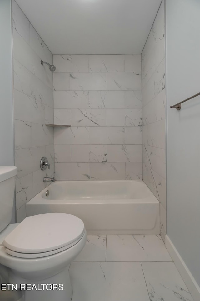 bathroom featuring tiled shower / bath combo and toilet